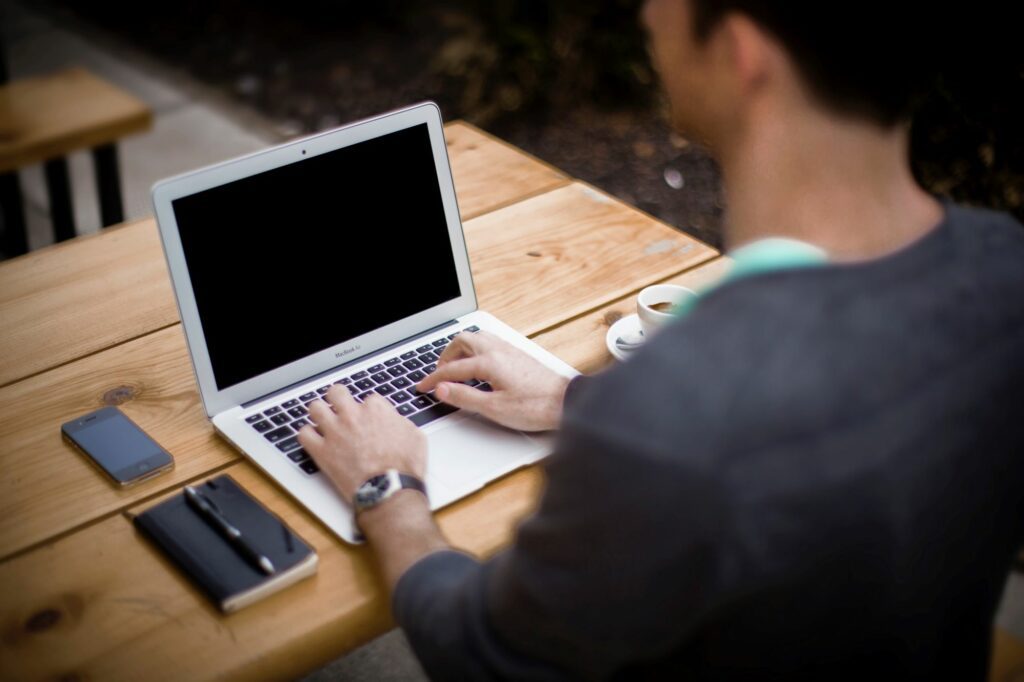 man typing on laptop with good posture