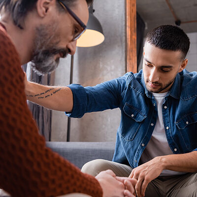 Middle-aged man sitting with his father, caregiving moment